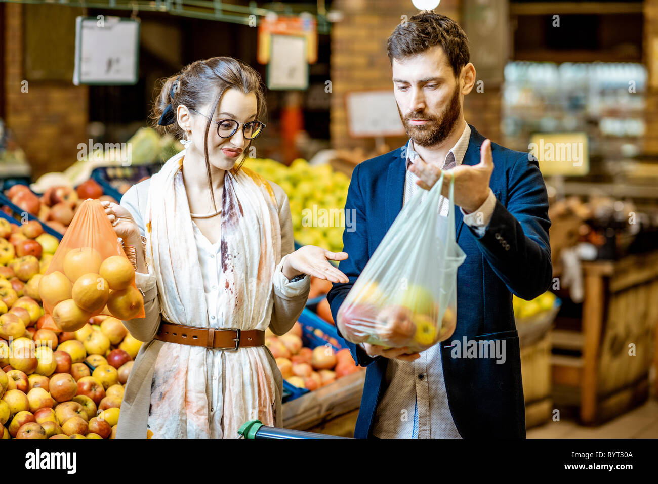 L'homme et la femme l'achat d'aliments à l'aide d'eco et sac en plastique dans le supermarché. Concept de l'utilisation d'eco sac pendant le shopping Banque D'Images