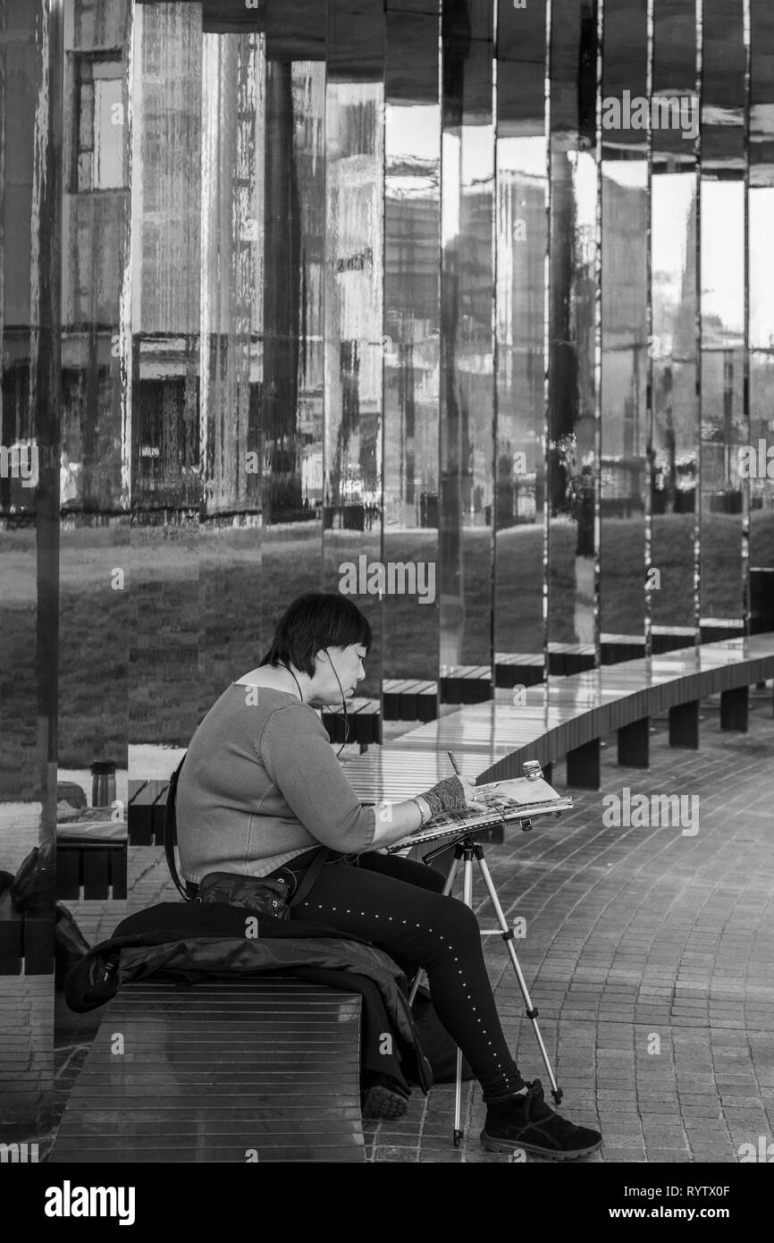 Une femme peintre travaillant à Hasholder Park, Kings Cross, London, UK.. Le miroir réfléchissant à côté allée. Appartements Tapisserie Banque D'Images