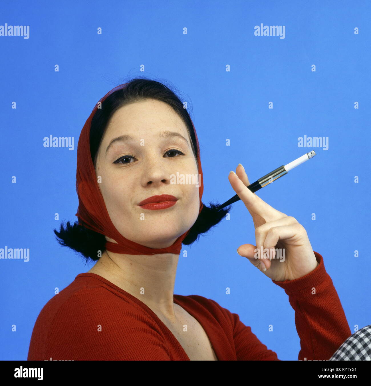 Les gens, les femmes, la femme en rouge wrap top, sous voile, tenant un fume-cigarettes, portrait, de la mode dans le style des années 50, Additional-Rights Clearance-Info-Not-Available- Banque D'Images