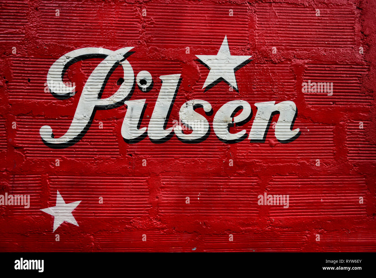 Rouge texturé mur peint avec le logo de la bière Pilsen,brassée depuis 1909, c'est la marque leader dans la région d'Antioquia en Colombie, en Amérique du Sud. Banque D'Images