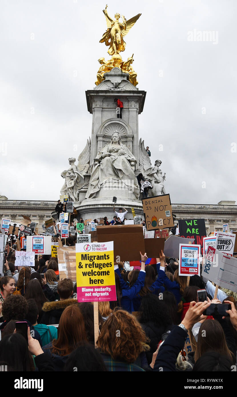 Les élèves l'ascension de la Queen Victoria Memorial pendant la grève de l'école pour le changement climatique à l'extérieur de Buckingham Palace, Londres, alors que les manifestations sont prévues dans 100 villages et villes au Royaume-Uni. Banque D'Images