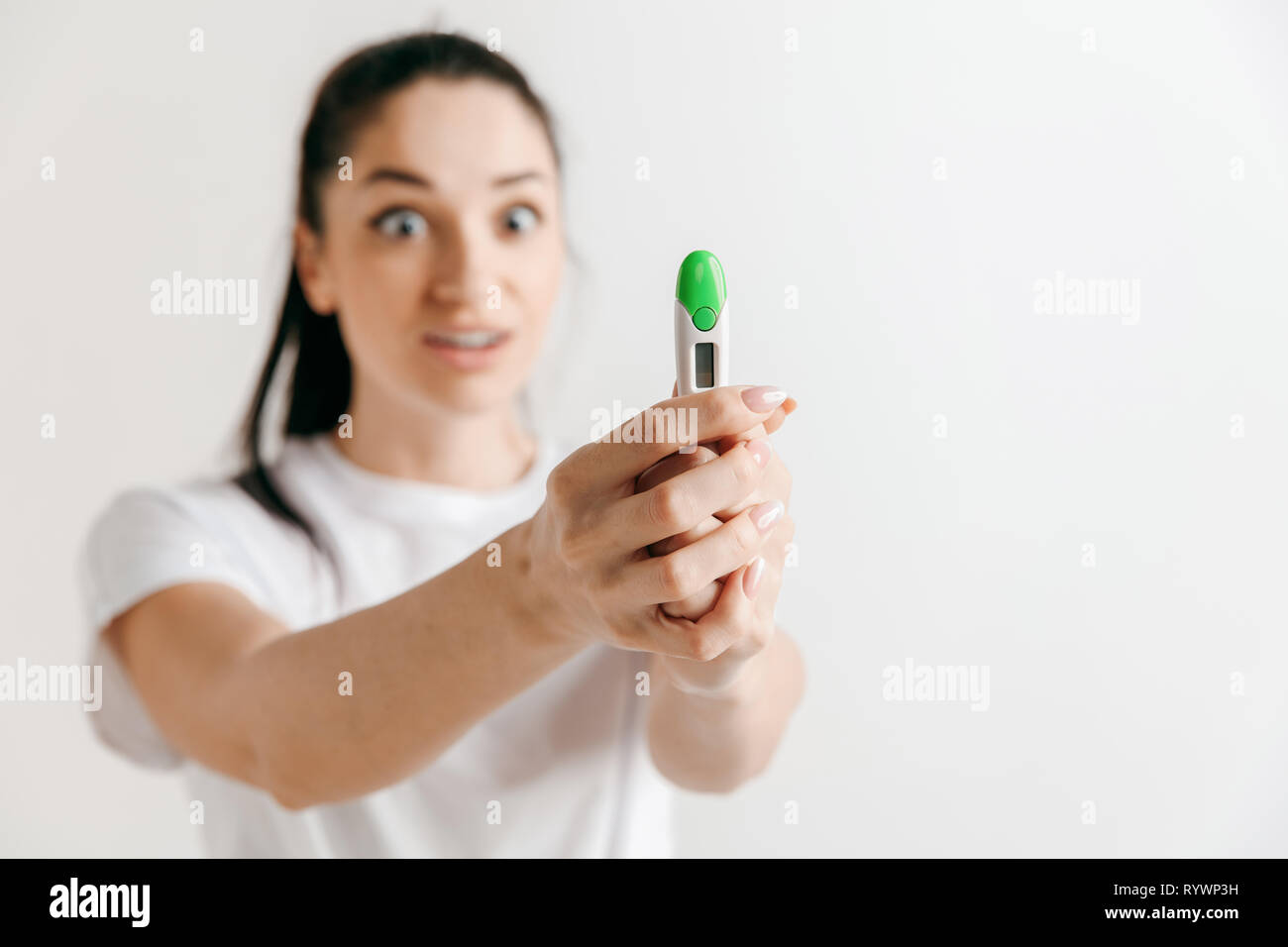 Jeune femme à la recherche sur les tests de grossesse au studio. Banque D'Images