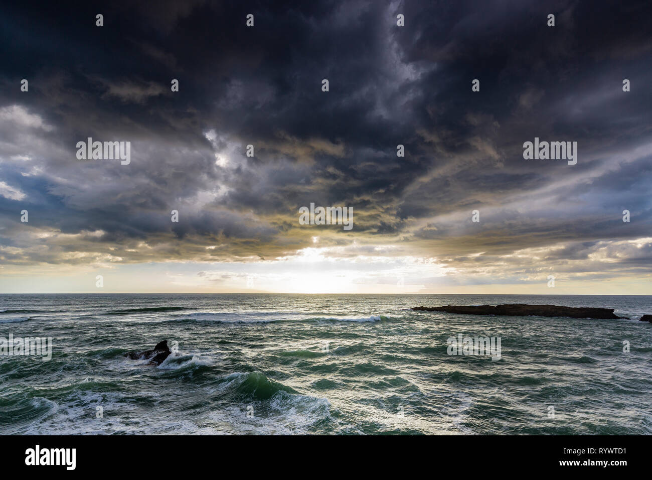 Rugueux, avec une mer de brouillard de pulvérisation et blanc, Coucher de soleil à travers les nuages à majestetic Kere Kere, Northland, Nouvelle-Zélande Banque D'Images