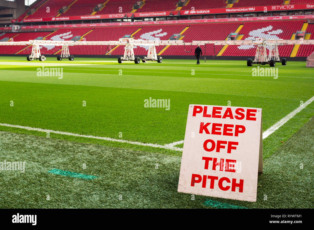 Veuillez garder hors du terrain signe par coin de jeu et équipement d'arrosage au sol en arrière-plan au Liverpool Football Club Anfield Road Stadium. Banque D'Images