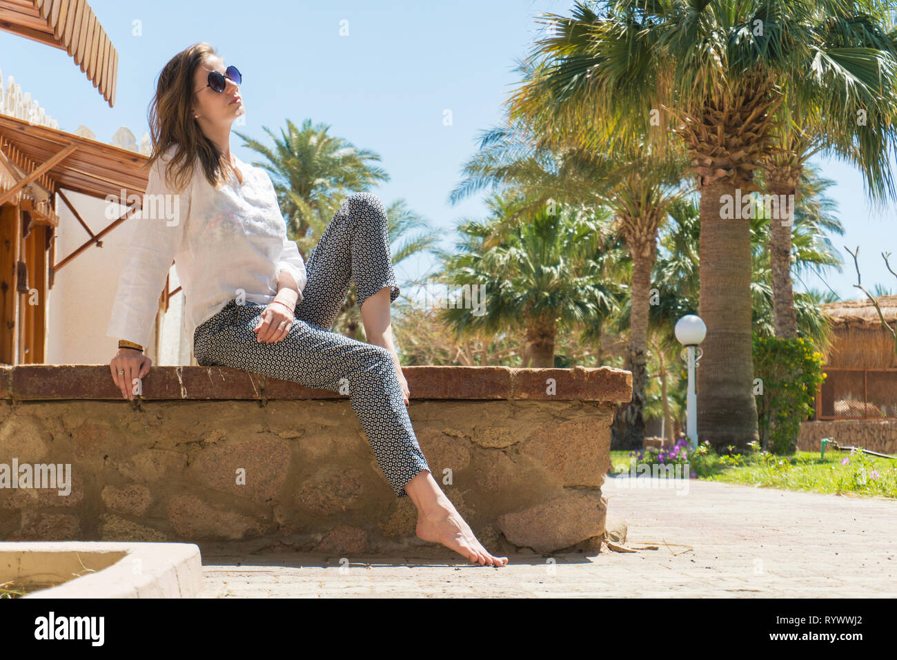 Pretty woman relaxing under sur sun resort Banque D'Images