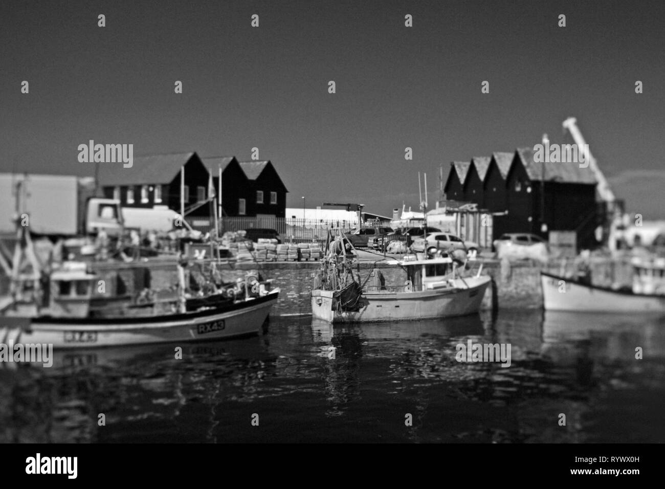 Bateaux de pêche et de cabanes de pêcheurs au port de Whitstable, Kent, Angleterre. Image prise avec un objectif de contrôle de la perspective et converti en monochrome. Banque D'Images