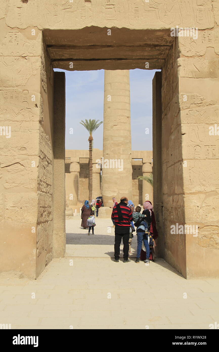 Les visiteurs de la famille, femme en hijab, debout dans une grande manière d'entrée en pierre, de la Cité parlementaire d'Amon-Rê, complexe du temple de Karnak, Louxor, Égypte Banque D'Images