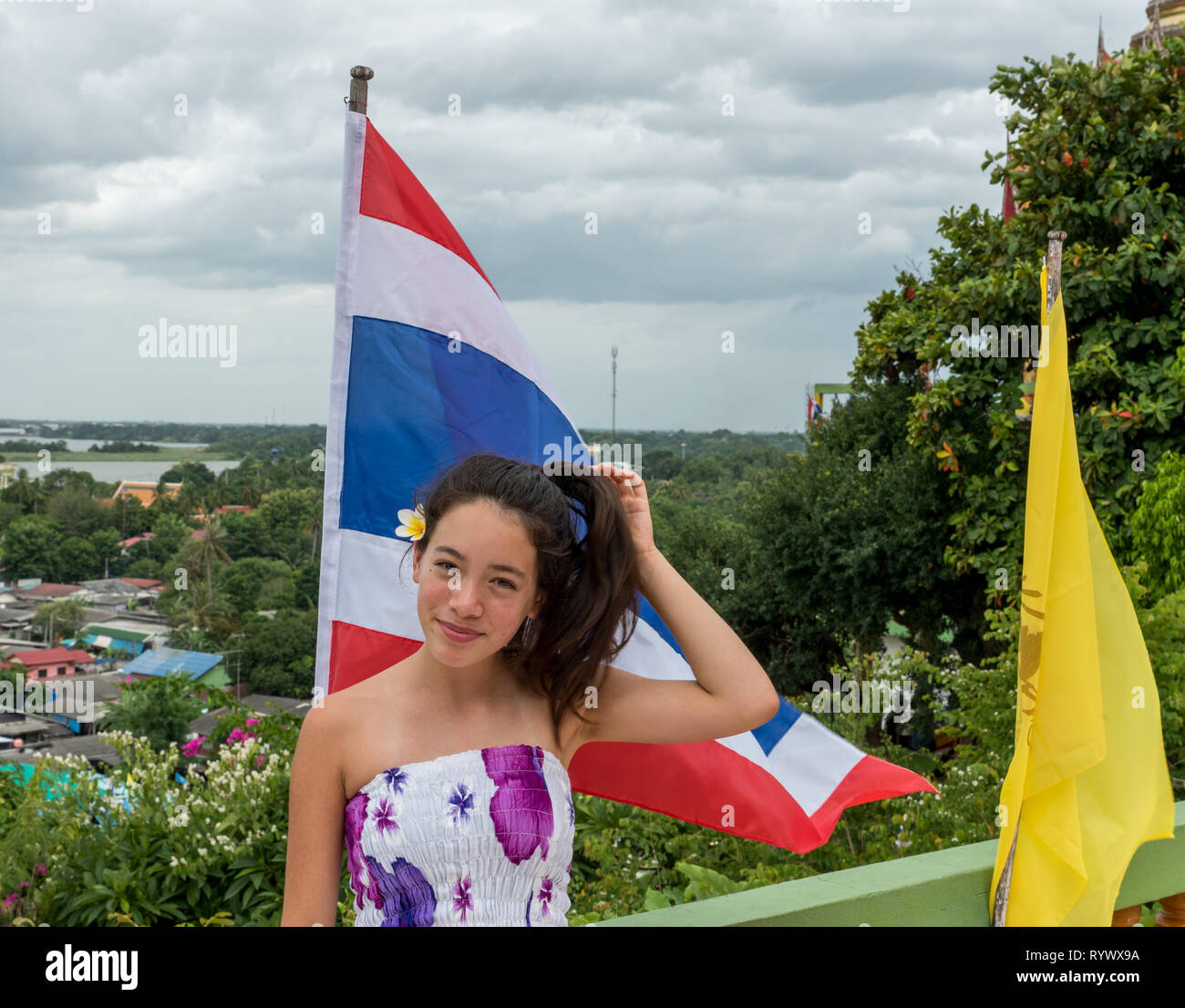 Smiling teen debout devant le drapeau thaïlandais avec en arrière-plan Banque D'Images