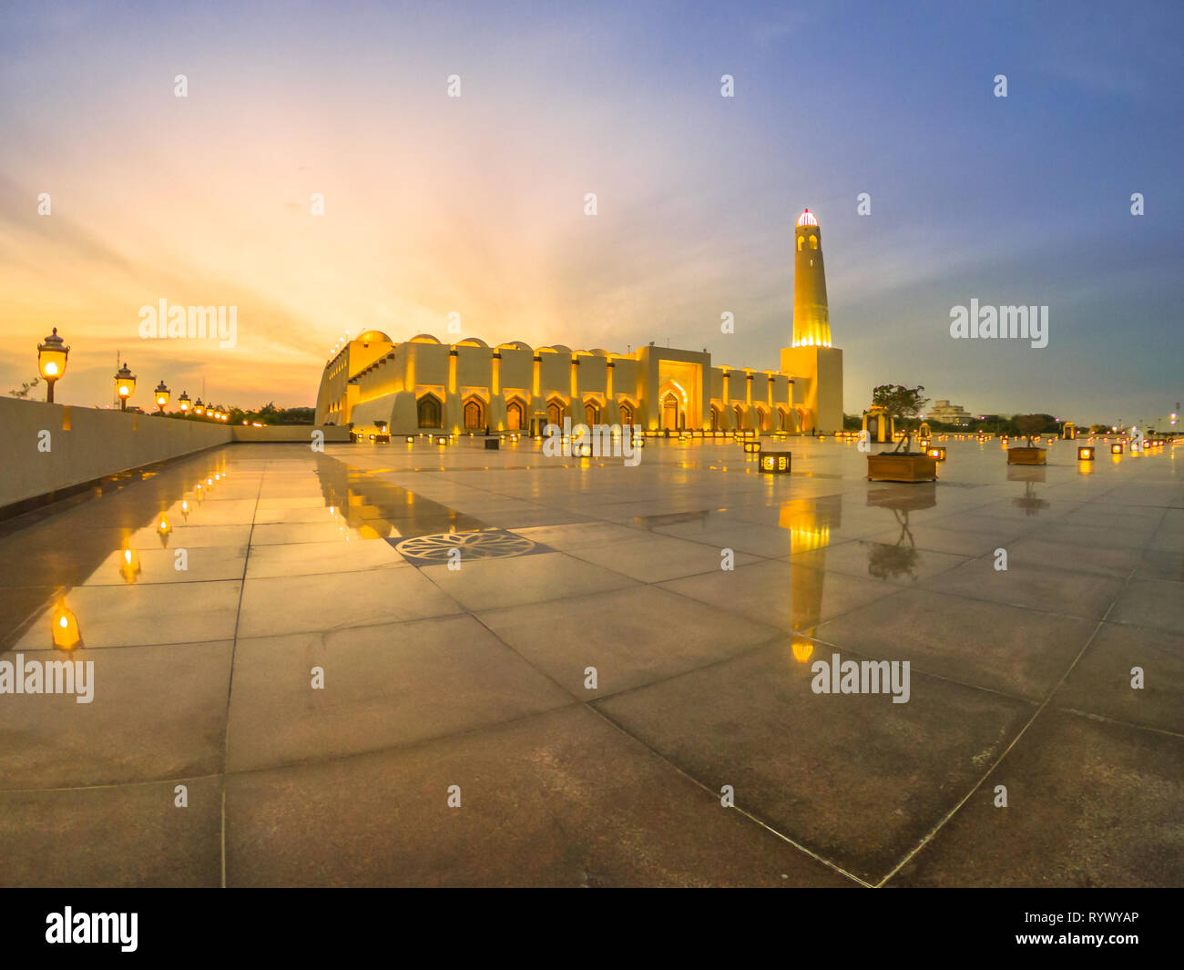 Grand angle de visualisation d'État Grande Mosquée avec un minaret au crépuscule, réfléchissant sur la chaussée en marbre à l'extérieur. Mosquée de l'État du Qatar, le Moyen-Orient, l'Arabian Banque D'Images