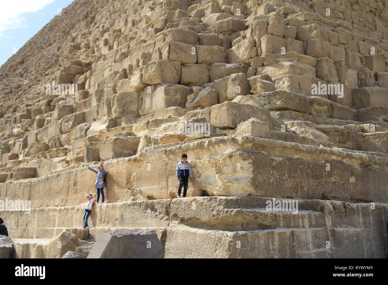 Enfants jouant sur la pyramide de Khafré malgré l'absence de signes d'escalade sur la première rangée de blocs, complexe Pyramide de Gizeh, Le Caire, Egypte Banque D'Images