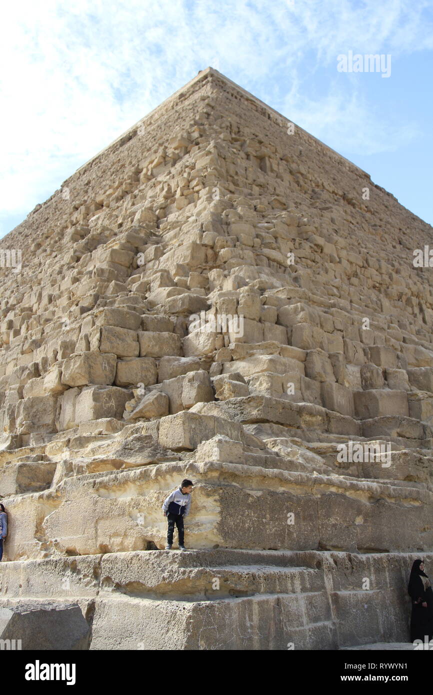 Jeune garçon jeter autour de l'angle de la base de la pyramide de Khafré, complexe Pyramide de Gizeh, Le Caire, Egypte Banque D'Images