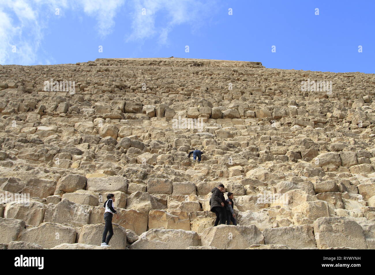 Escalade pour les enfants la pyramide de Khafré malgré l'absence de signes d'escalade sur la première rangée de blocs, complexe Pyramide de Gizeh, Le Caire, Egypte Banque D'Images