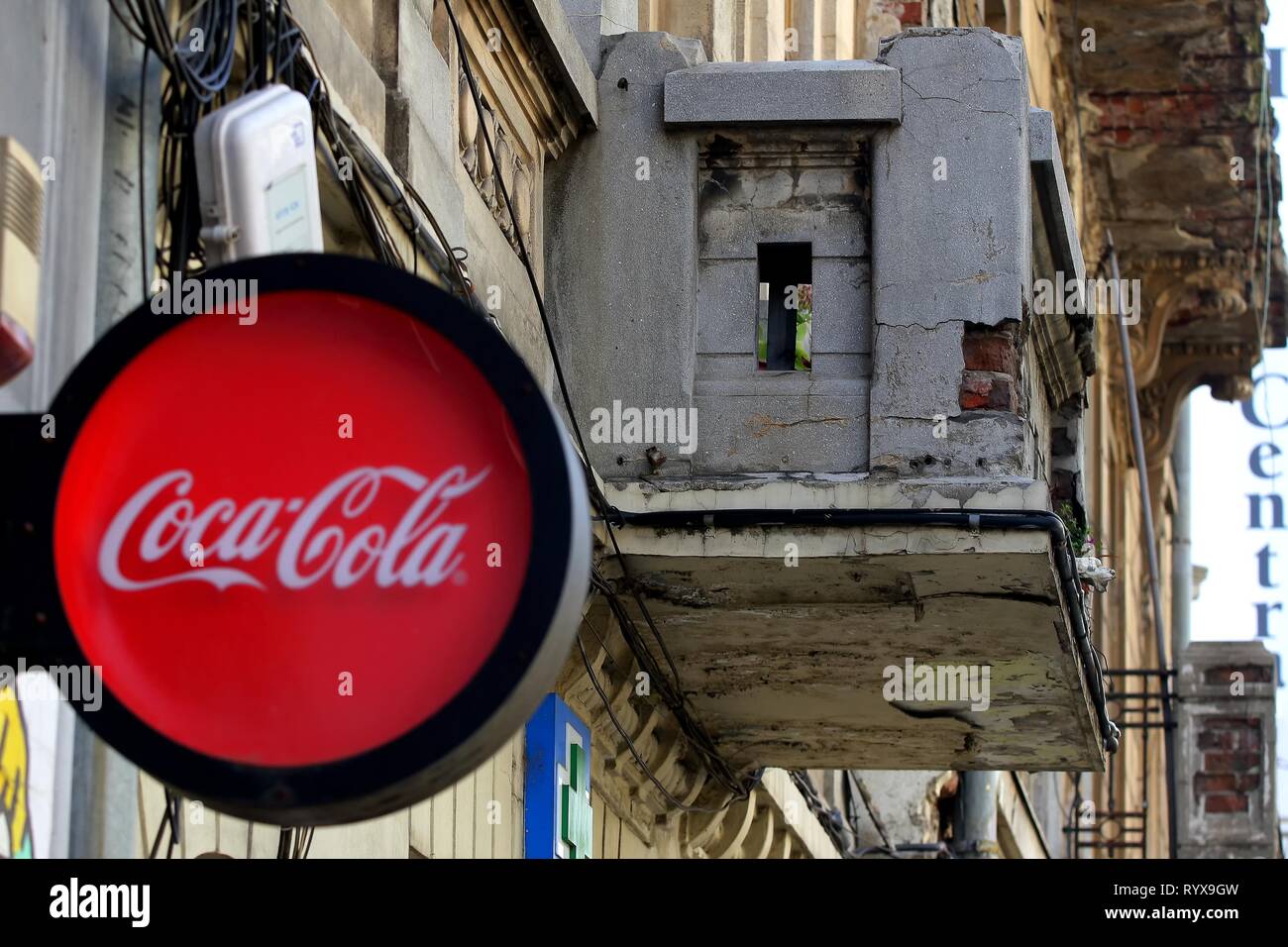 Bucarest, Roumanie - 10 octobre 2018 : un logo de fabricant de boissons gazeuses Coca-Cola s'affiche sur le devant d'un petit marché près d'un vieux bâtiment l Banque D'Images