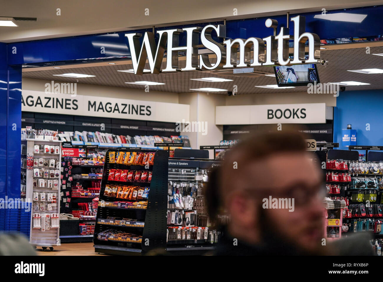Londres, Royaume-Uni - 05 Février, 2019 : Inconnu homme marche en face de la direction générale de WHSmith à l'aéroport de Londres Luton. WHS est grand détaillant britannique Banque D'Images