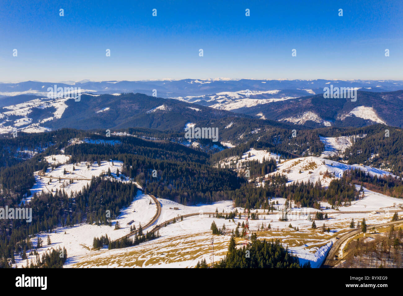 Forêt et route sinueuse dans un paysage d'hiver, vue aérienne Banque D'Images