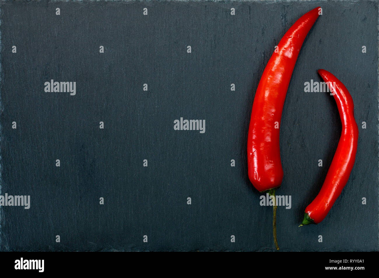 Red hot peppers sur plaque ardoise foncé avec copie espace. Fond texturé en pierre naturelle Banque D'Images