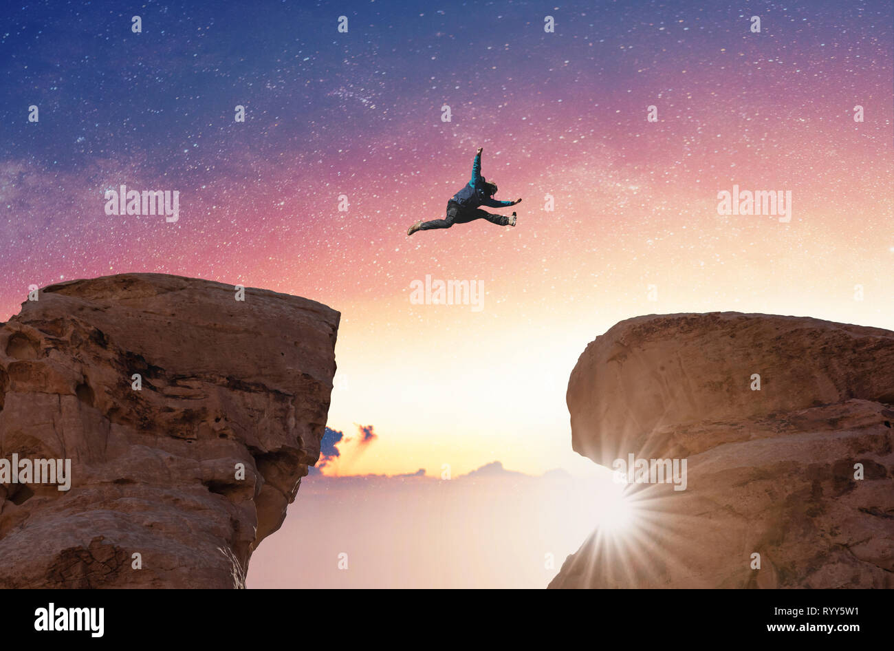 Défi, le risque, la liberté et l'imagination concept. Une Silhouette man jumping over précipice crossing cliff Banque D'Images