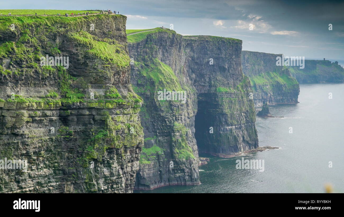 Les magnifiques falaises de Moher en Irlande avec un bon nombre de touristes se rendant sur le terrain dans le pays Banque D'Images