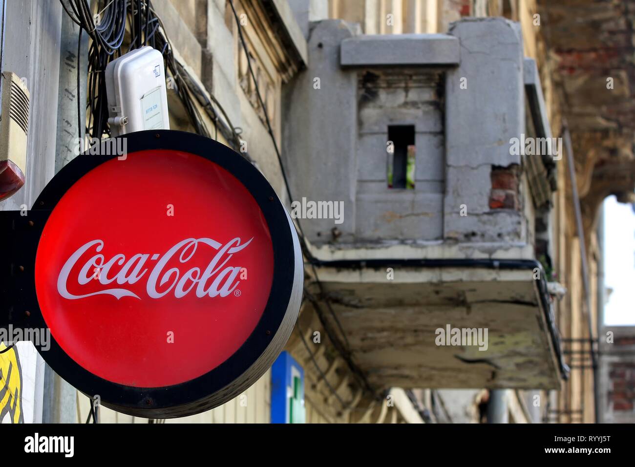 Bucarest, Roumanie - 10 octobre 2018 : un logo de fabricant de boissons gazeuses Coca-Cola s'affiche sur le devant d'un petit marché près d'un vieux bâtiment l Banque D'Images
