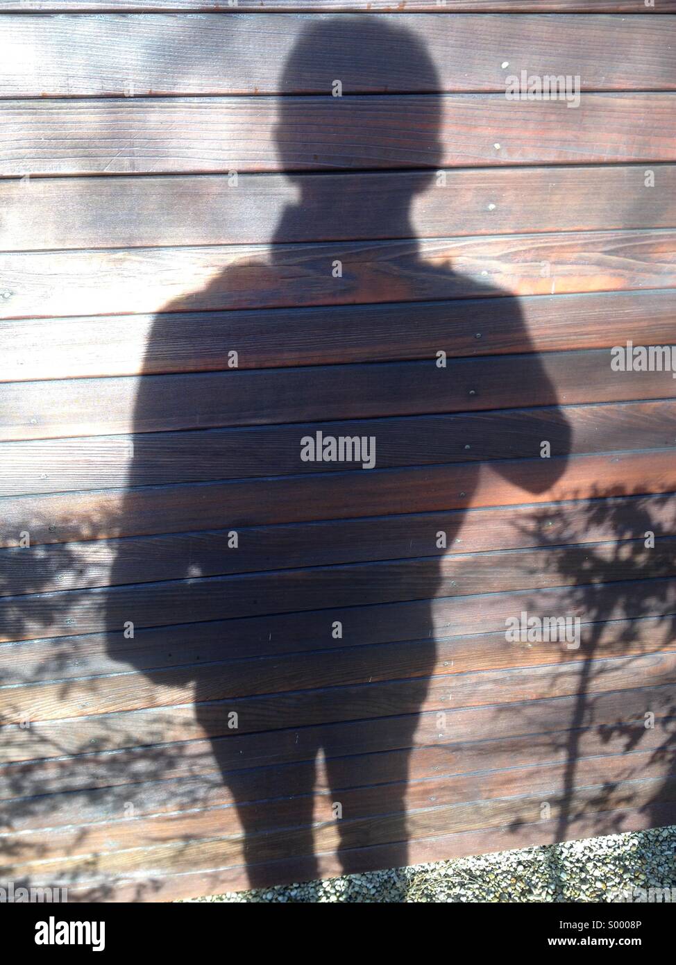 Shadow of a man taking photo sur mur en bois Banque D'Images