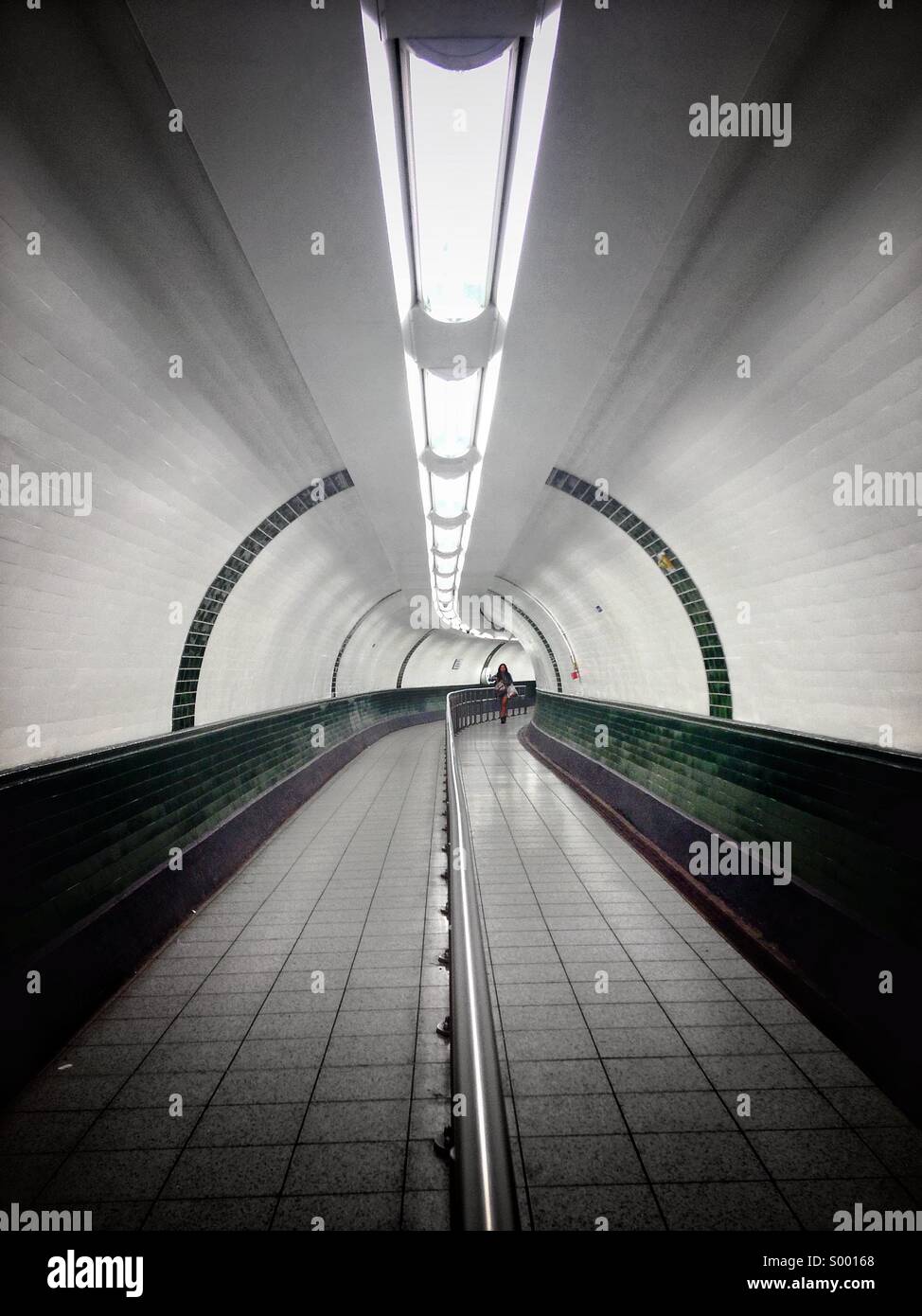 Woman walking through tunnel. Banque D'Images