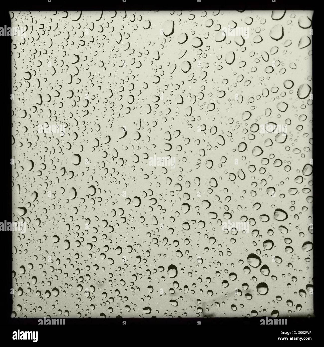 À l'intérieur d'une voiture à la recherche d'un pare-brise couvert de pluie Banque D'Images