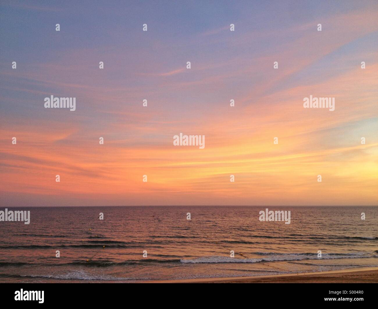 Vue sur le coucher du soleil glorieux sont une agrafe dans la destination de vacances de luxe Val de Lobo dans l'Algarve, au Portugal. Banque D'Images