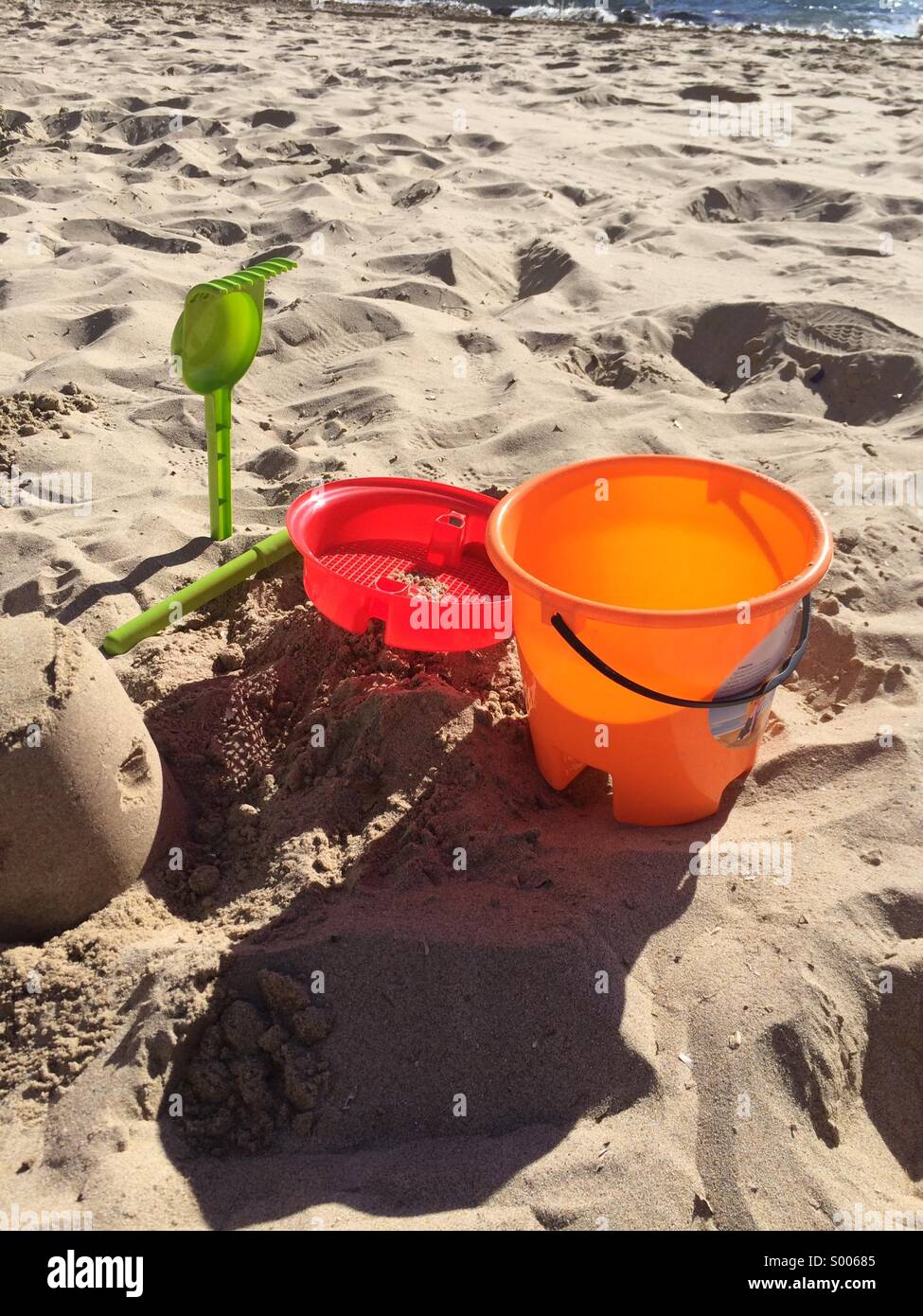 Pelle à benne et château de sable sur la plage Banque D'Images