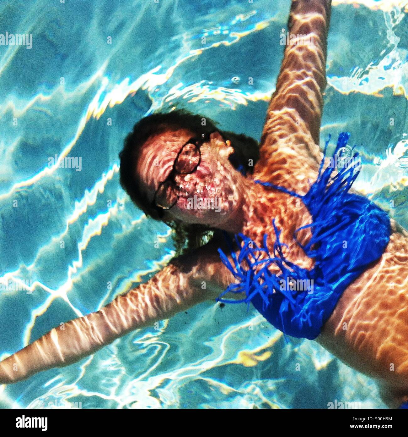 Femme avec des lunettes sous l'eau à la piscine Banque D'Images