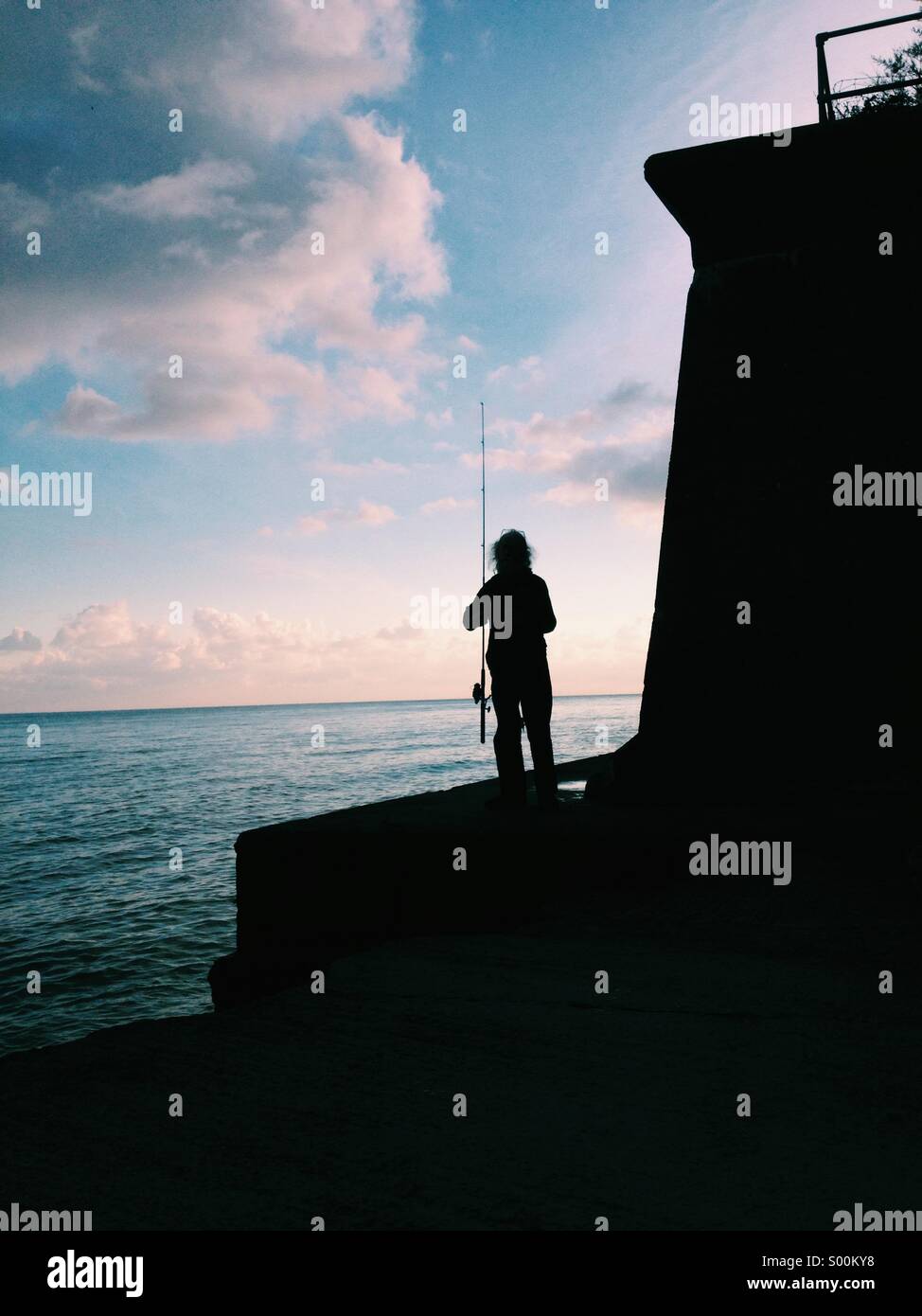 Sillouette d'un pêcheur au bord de la mer Banque D'Images