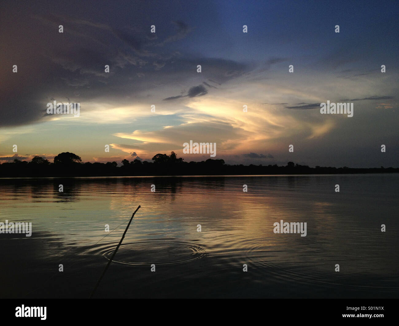 Amazon River avec canne à pêche au coucher du soleil Banque D'Images