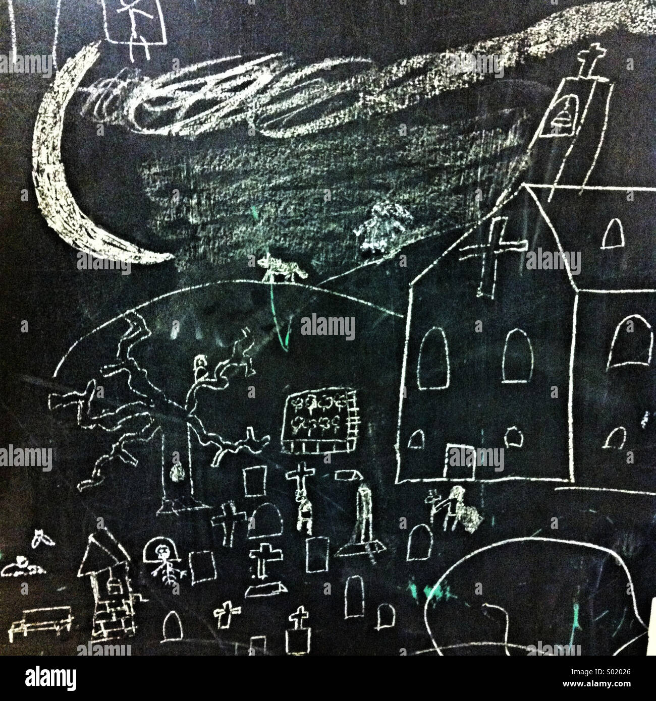 Un dessin d'enfant d'une église et un cimetière sur un tableau - Image de stock capturée avec un smartphone