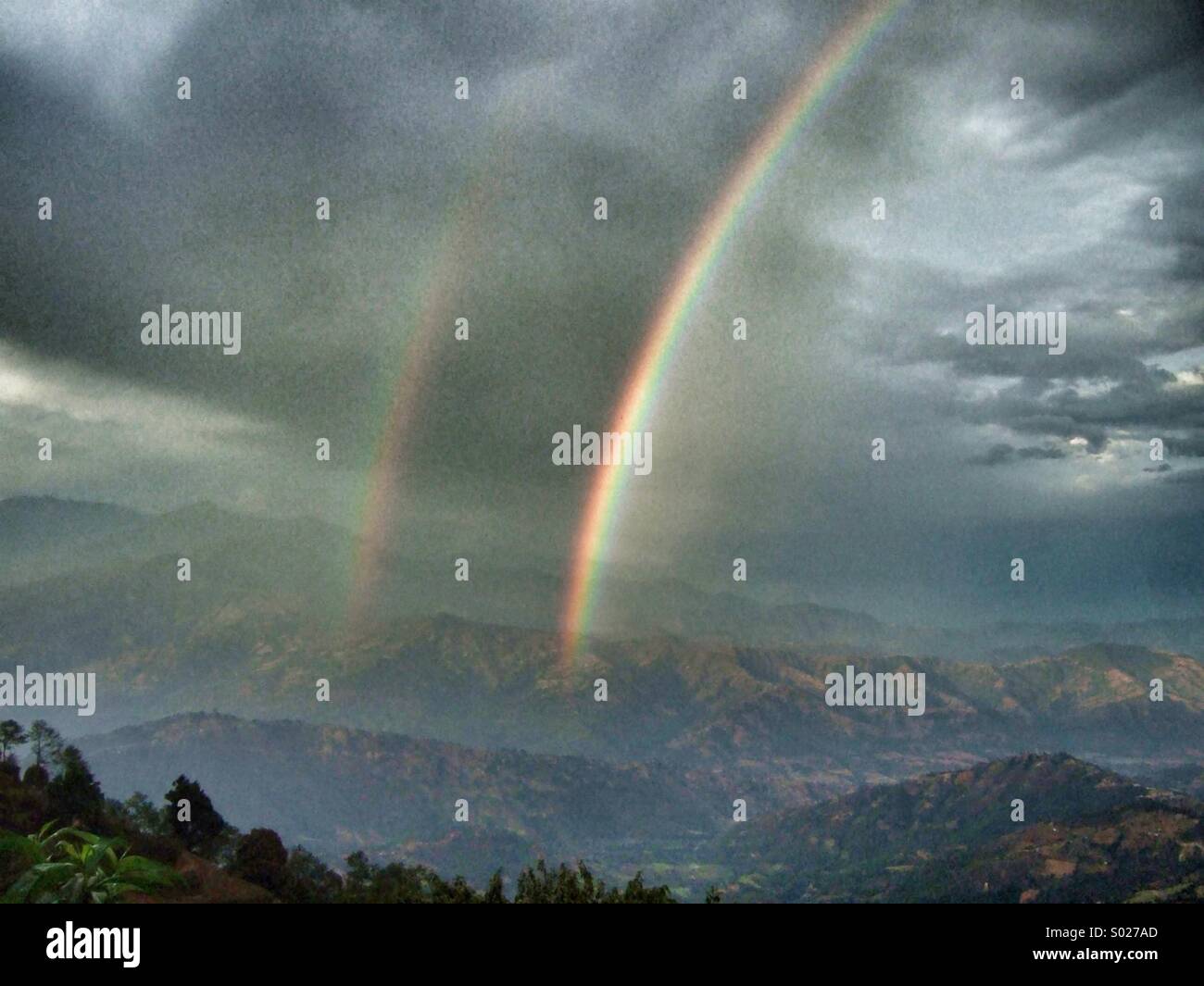 Double arc-en-ciel dans les montagnes Banque D'Images