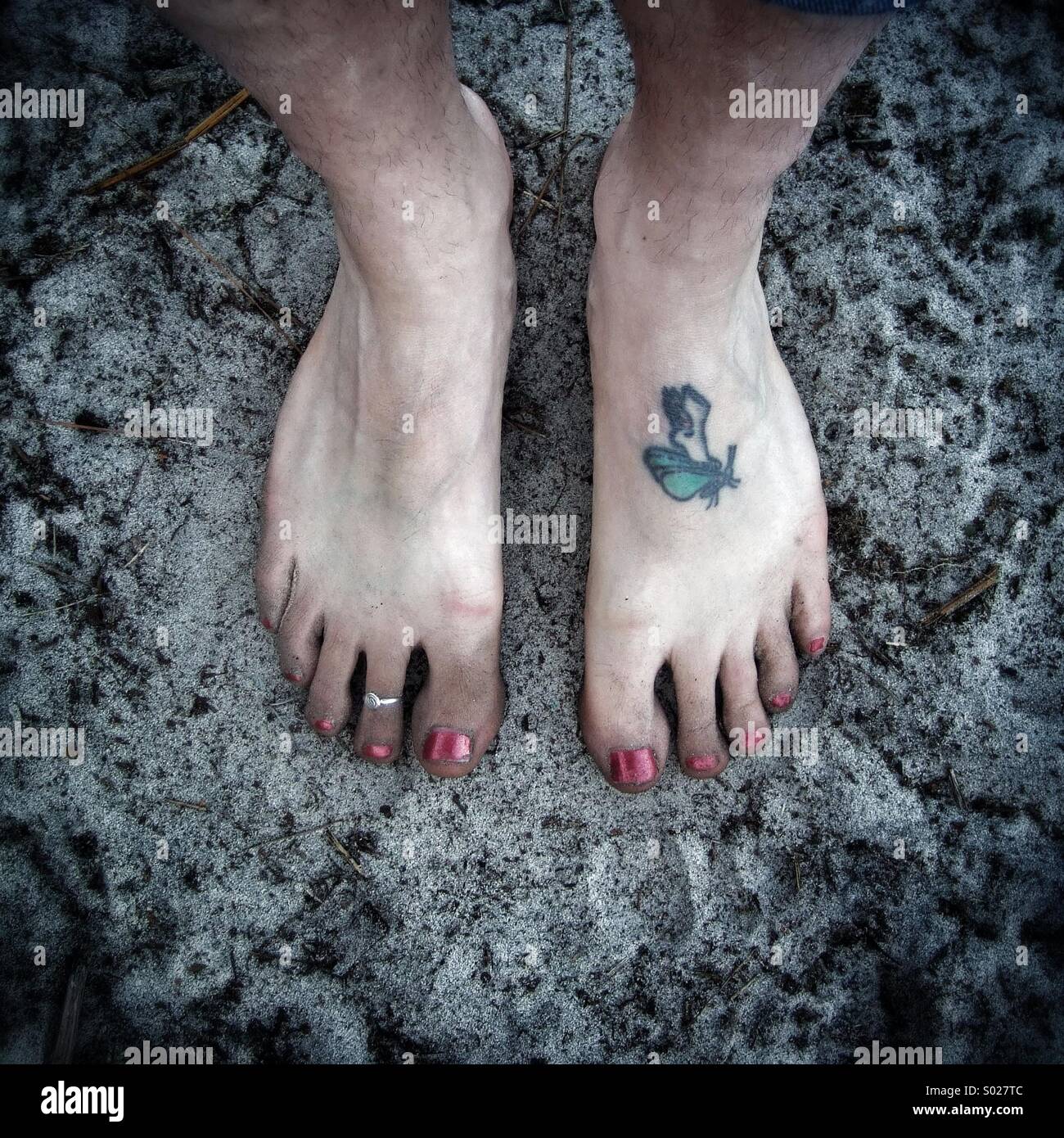 Pieds de Femme avec tatouage inhabituelle dans le sable à la plage. Banque D'Images