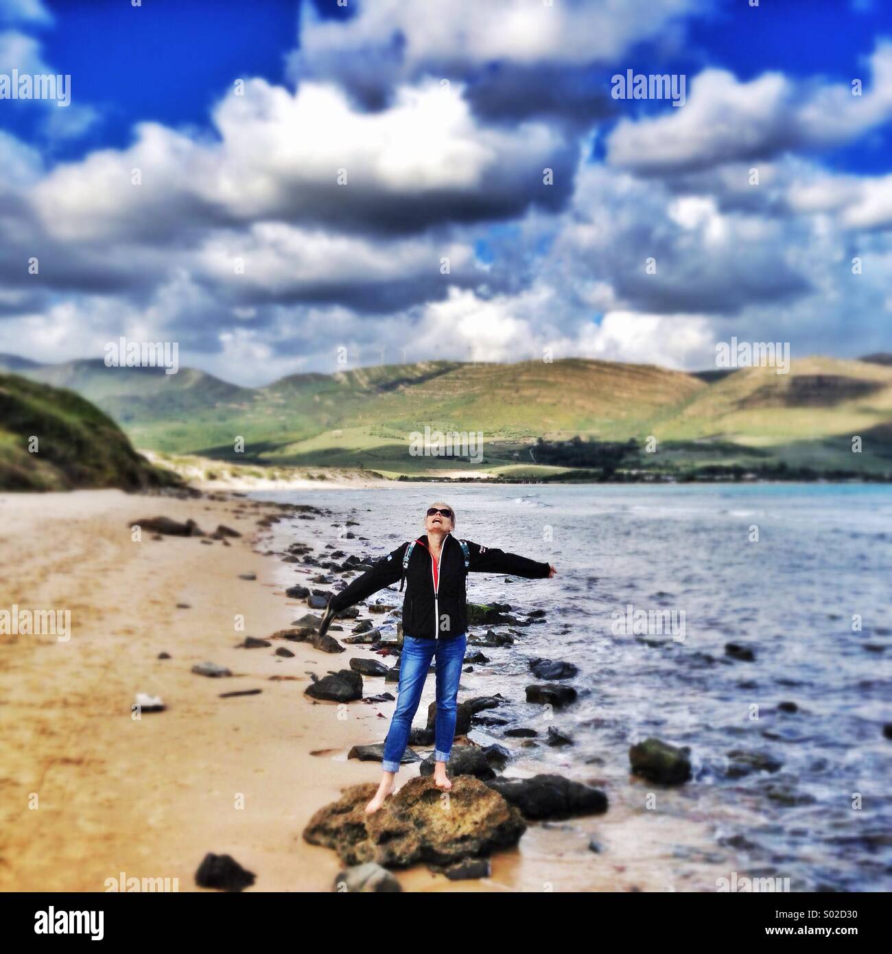 L'extérieur Girl standing on rock at the beach Banque D'Images