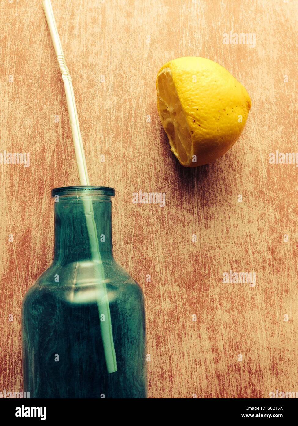 Le flacon en verre avec de la paille et de citron séché Banque D'Images