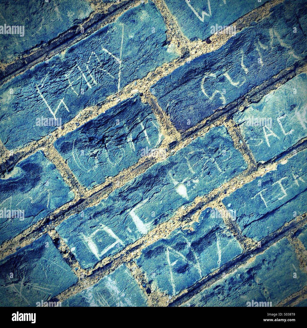 Graffiti sur un mur de brique en bleu Banque D'Images