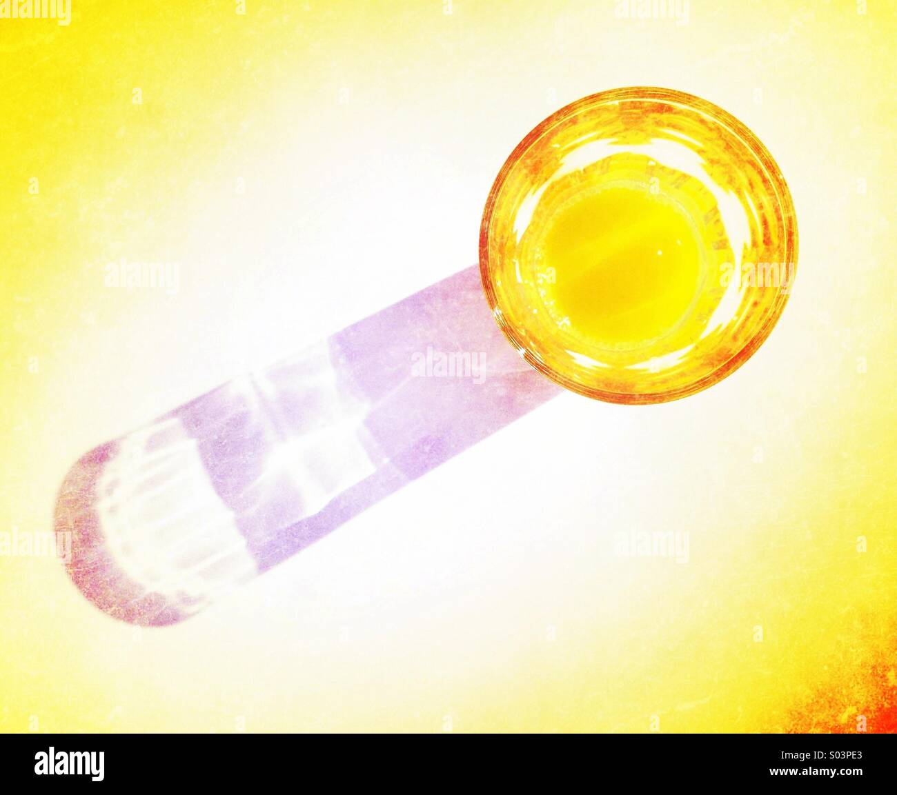 Verre de jus d'orange casting long shadow Banque D'Images