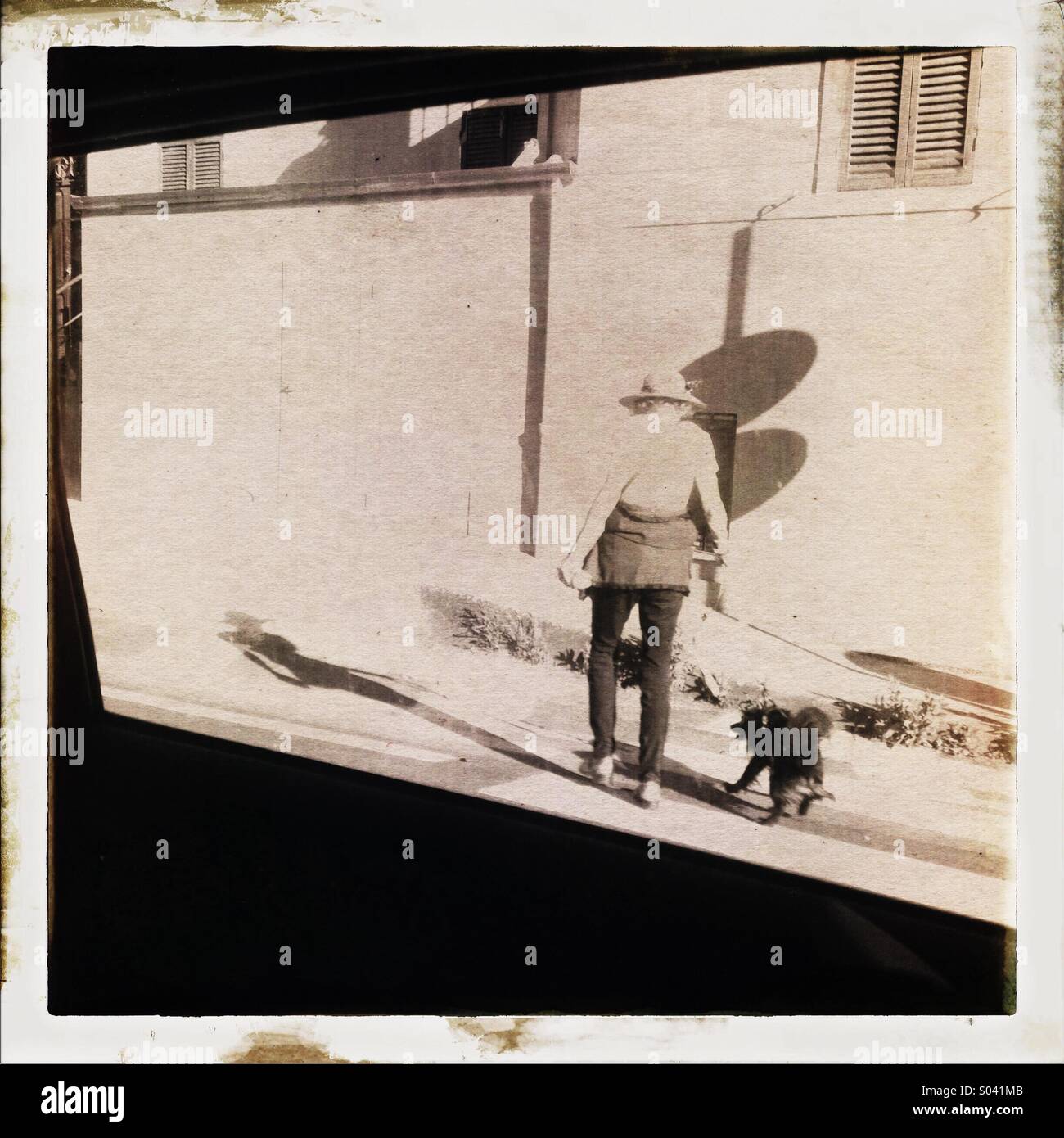 Femme âgée vu de l'arrière sur rue avec chapeau et chien - Image de stock capturée avec un smartphone