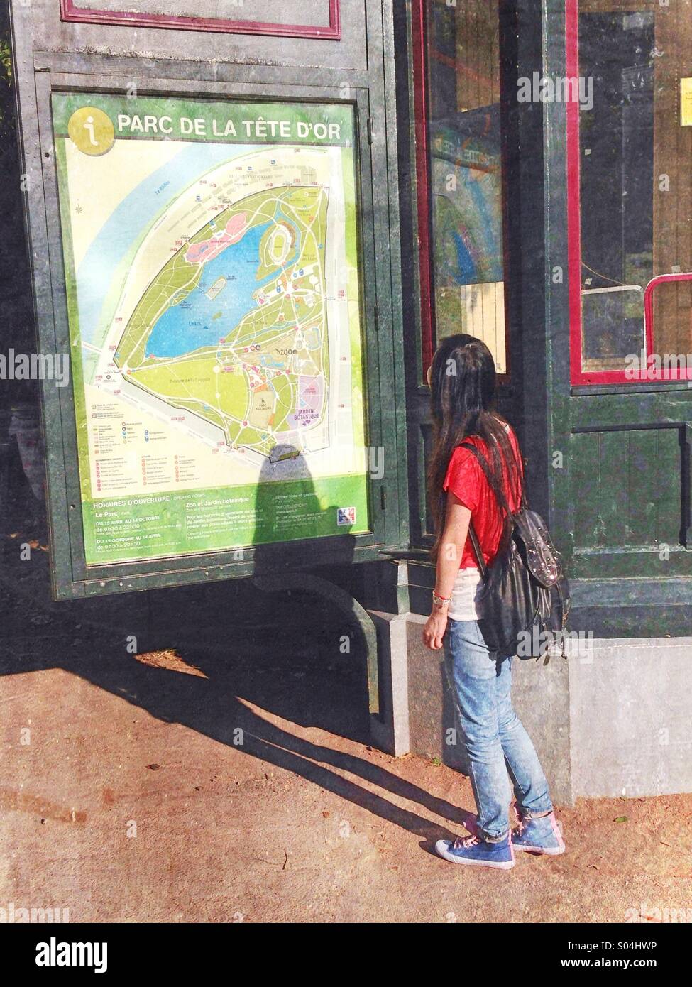 Une jeune femme à une carte du parc de la tête d'Or,France Banque D'Images Une jeune femme à une carte du parc de la tête d'Or,France Banque D'Images
