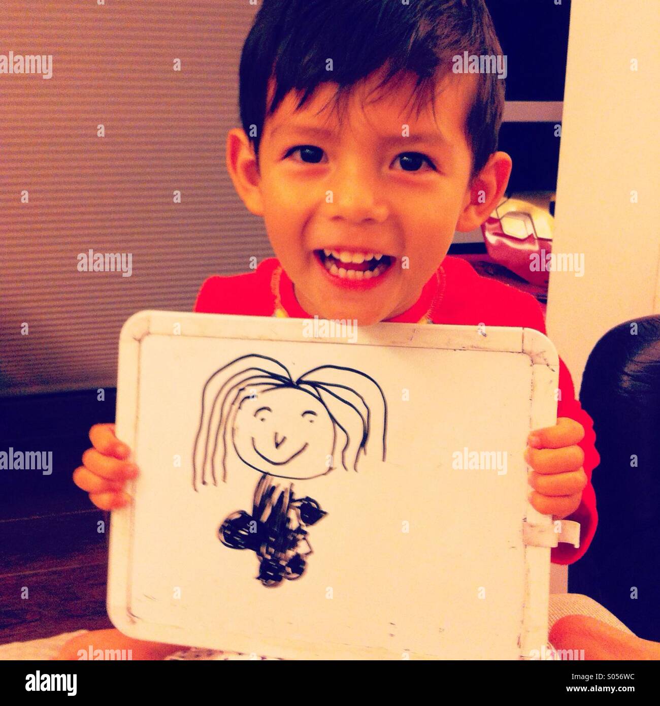 C'est une photo d'un enfant très heureux garçon qui montre fièrement ce qu'il vient de tirer sa mère : - Image de stock capturée avec un smartphone