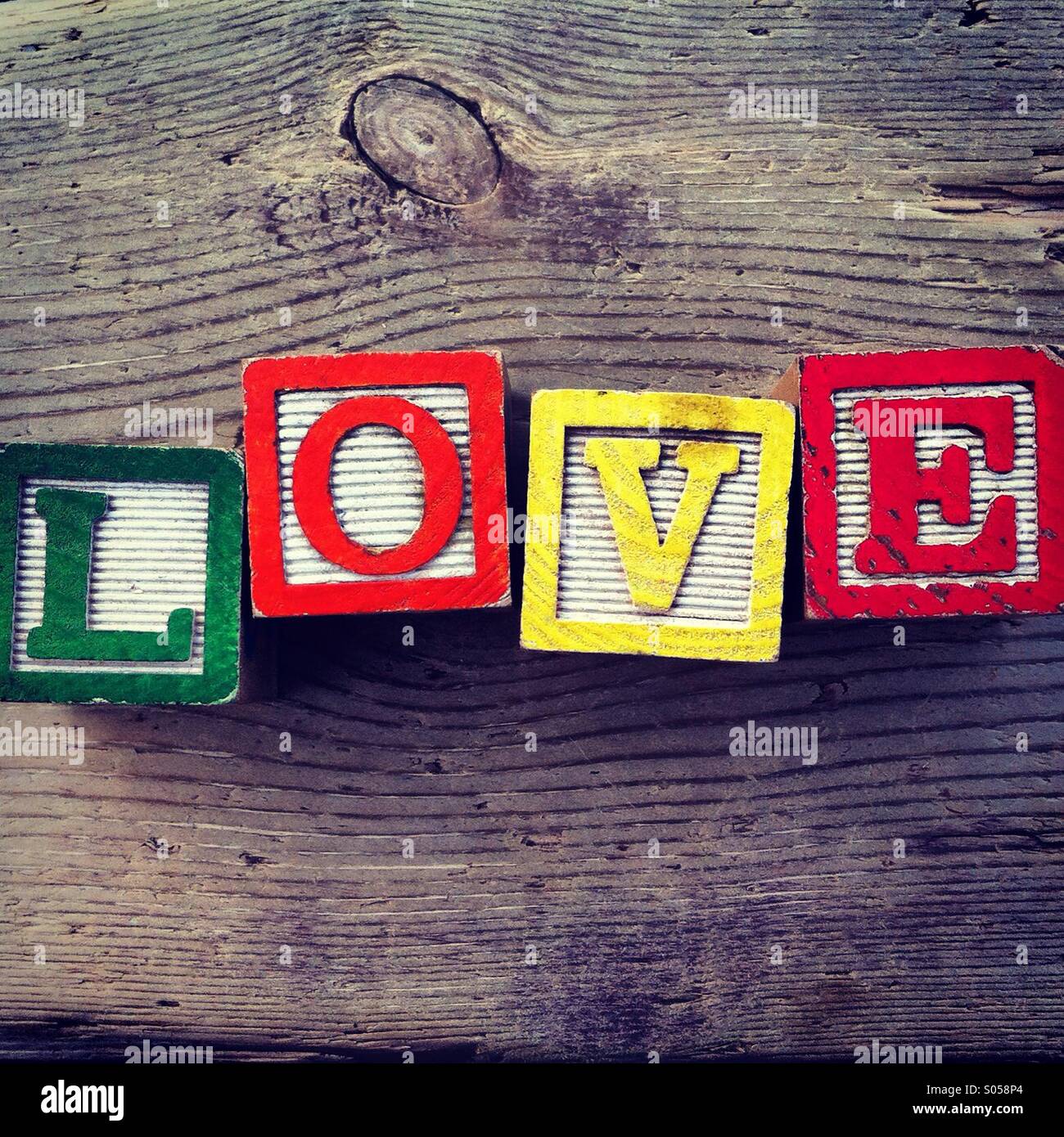 C'est une photo de deux cubes en bois jouet avec des lettres qui forment le mot amour - Image de stock capturée avec un smartphone