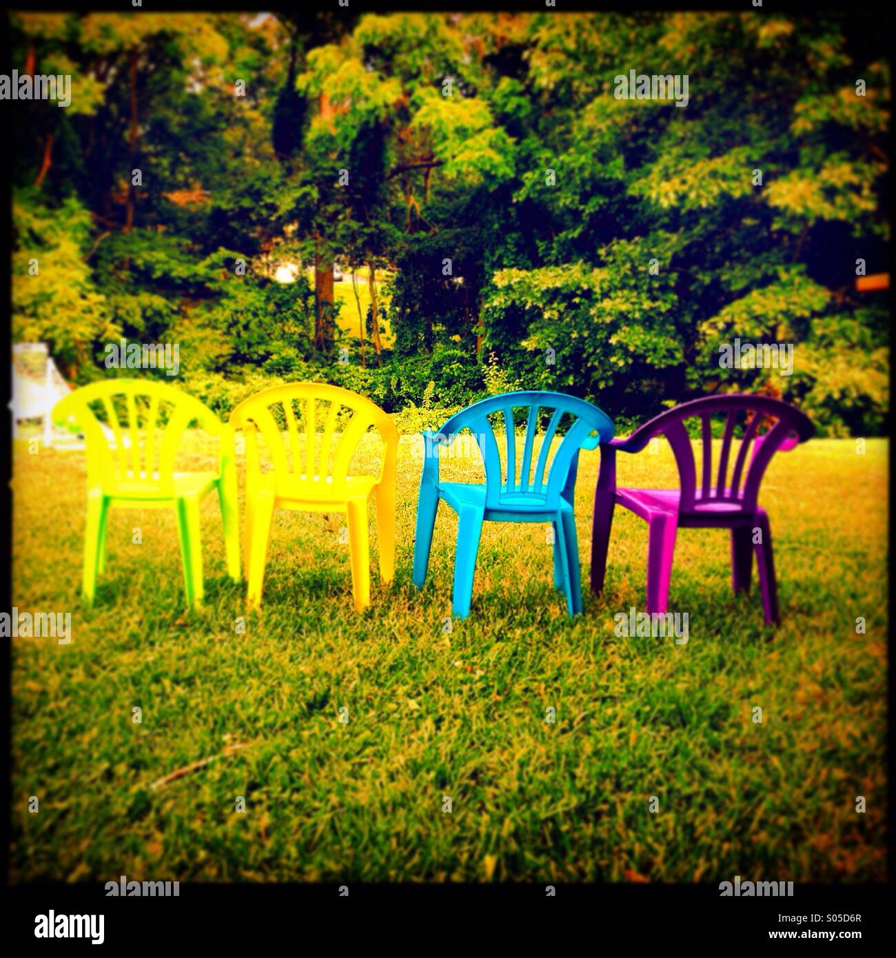 Une rangée de chaises pour enfants colorés lors d'une fête. Banque D'Images