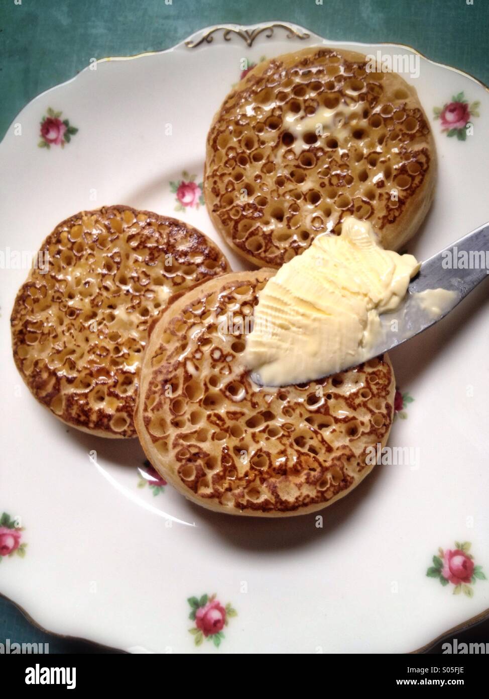 Hot buttered crumpets sur une jolie assiette Banque D'Images