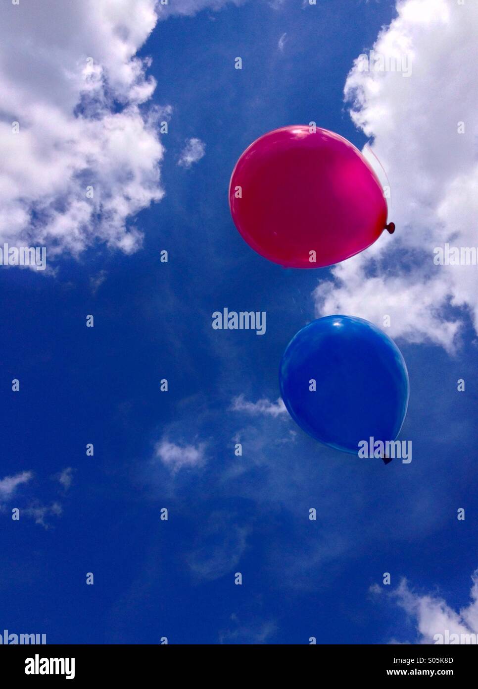 Ballons bleu et rouge flottant dans le ciel Banque D'Images Ballons bleu et rouge flottant dans le ciel Banque D'Images