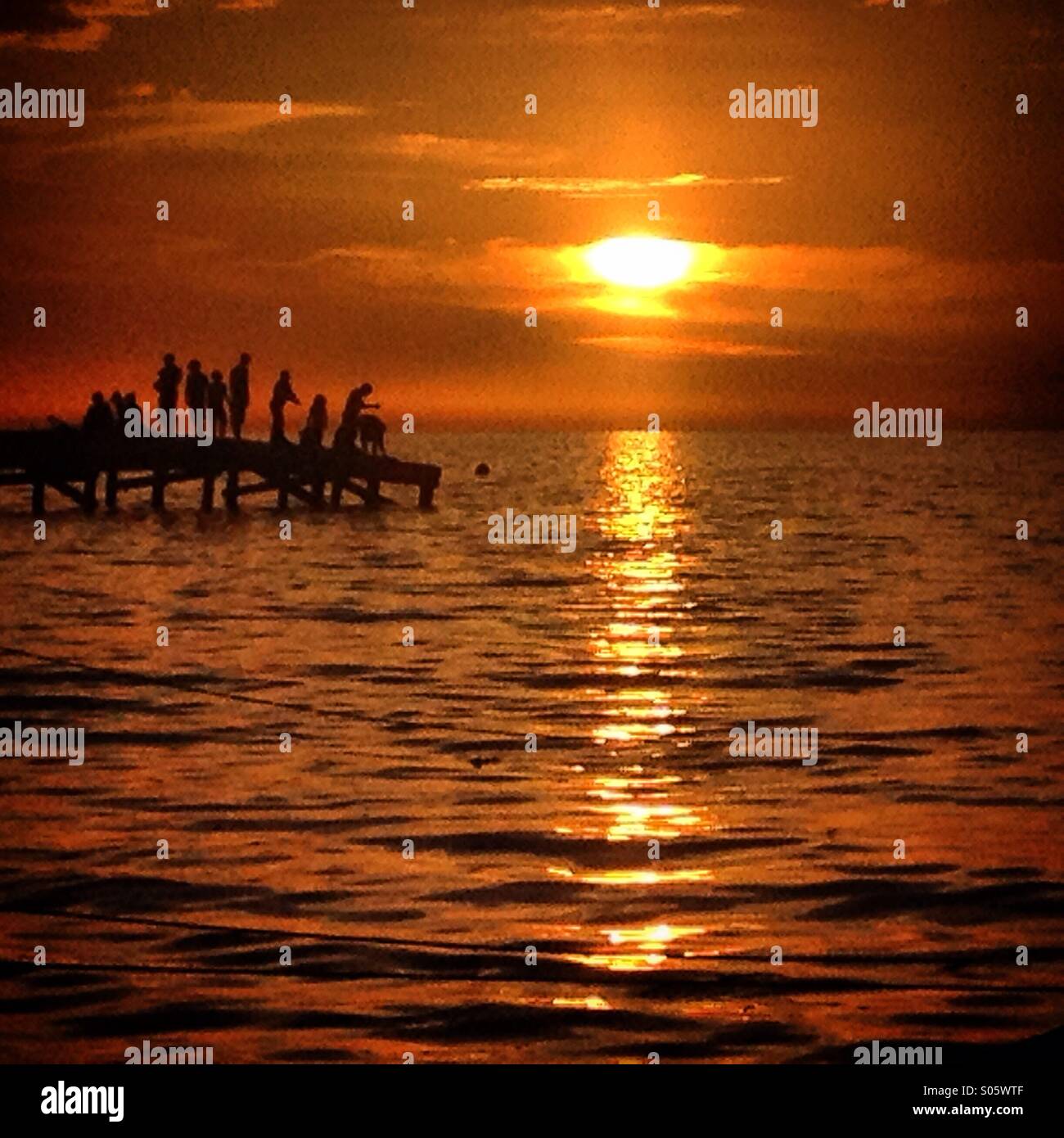 Les gens restent debout sur le quai au coucher du soleil dans l'île de Holbox, Quintana Roo, Mexique - Image de stock capturée avec un smartphone