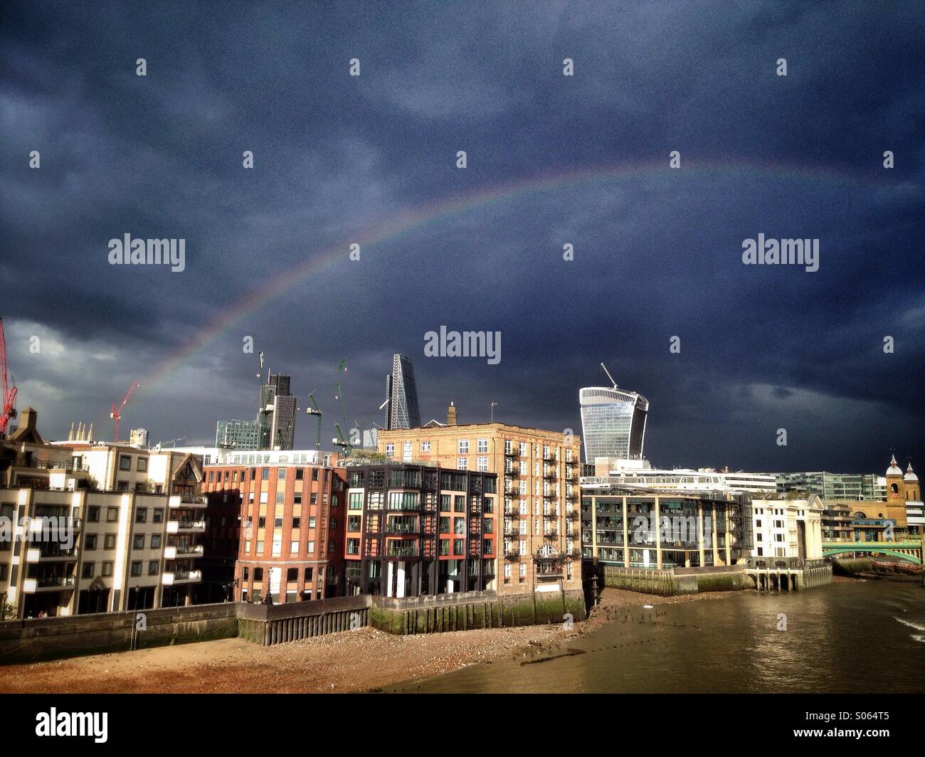 Un arc-en-ciel dans un ciel d'orage sur le quartier financier de la ville de London, England, UK Banque D'Images