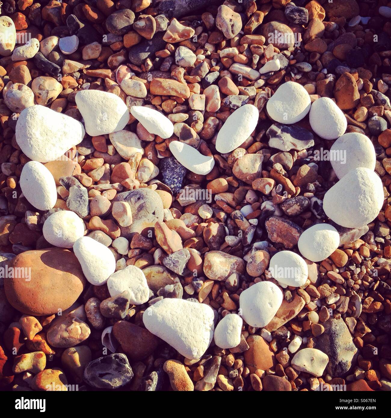 Coeur de galets blancs sur une plage de galets Banque D'Images