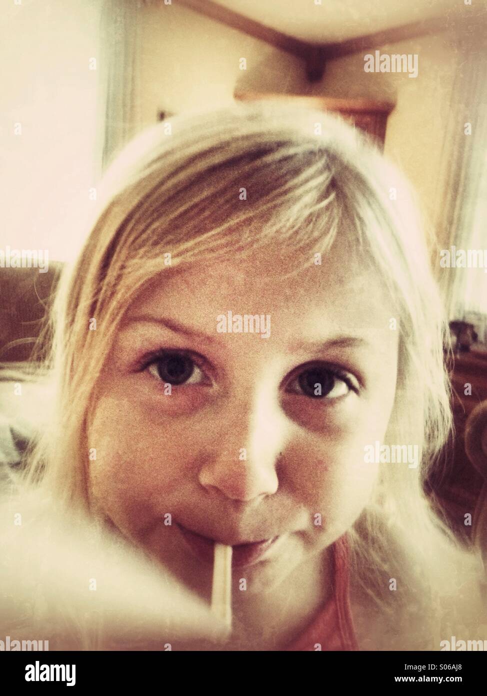 Une fille jouant avec une paille. Banque D'Images