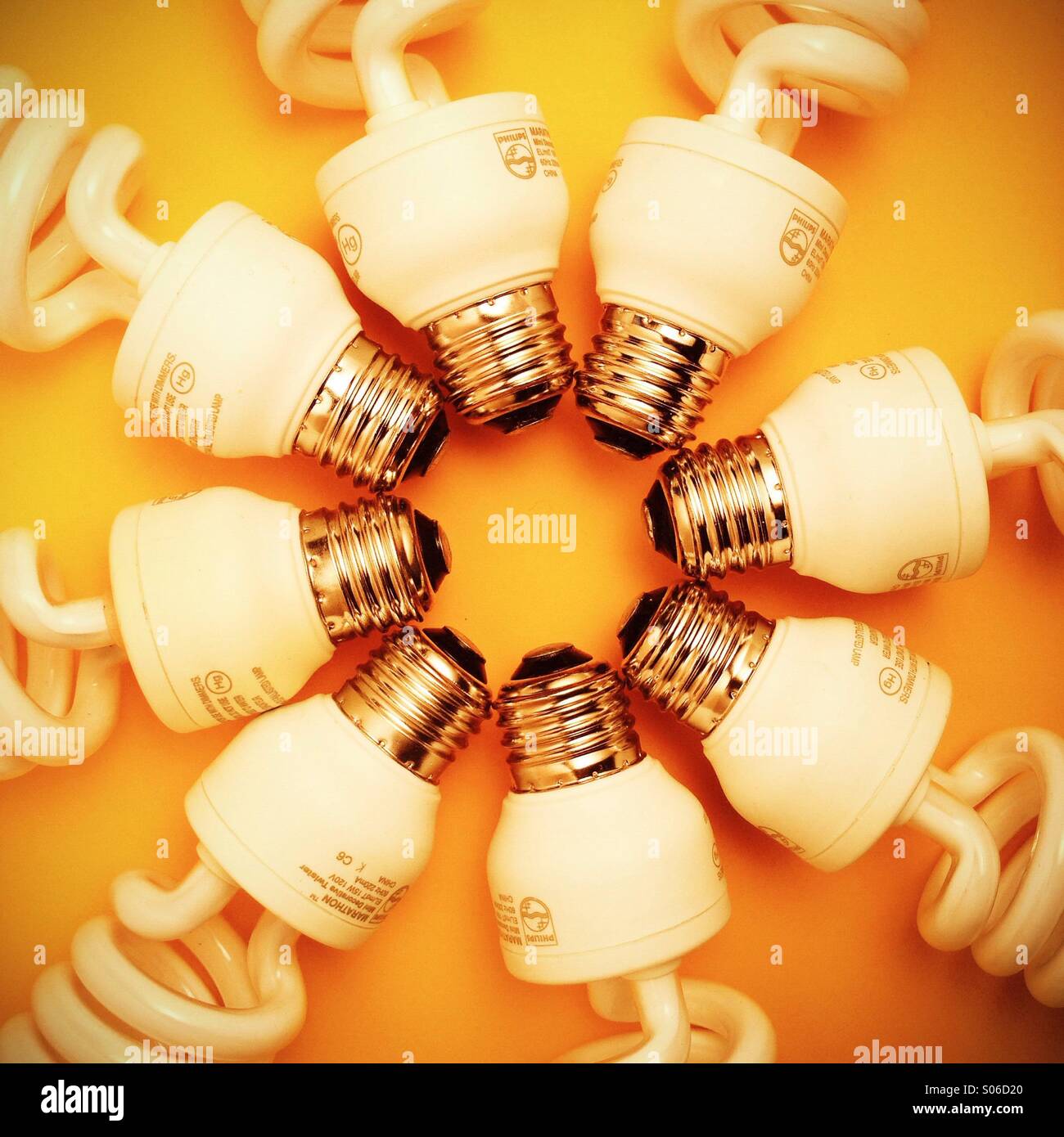 Les ampoules fluorescentes compactes disposées sur un fond jaune Banque D'Images